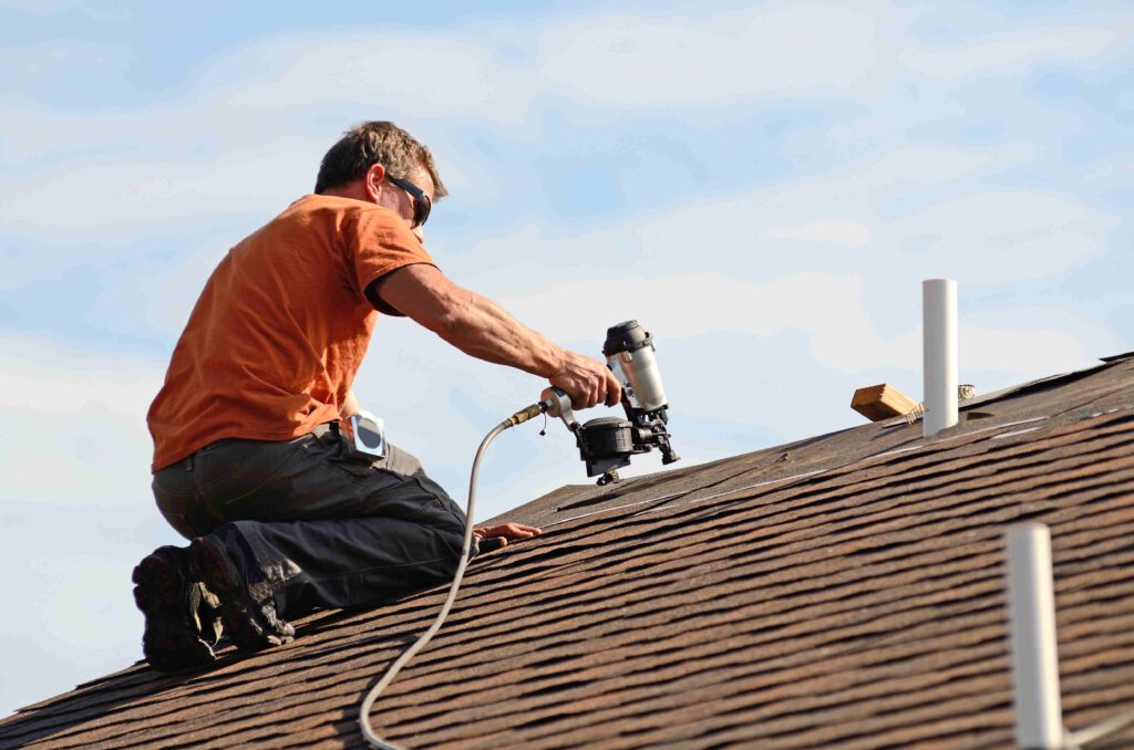 Finishing roof installation Roofing contractor finishing roof installation with nail gun