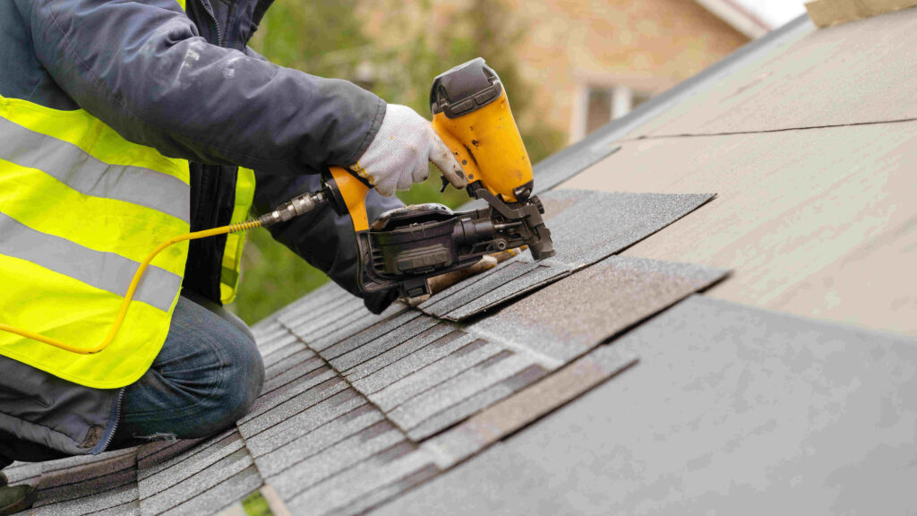 Roof installation nail gun Securing shingles to roof with pneumatic nail gun
